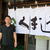 豚丼と摩周そばの店「くまうし」札幌川沿店の暖簾を背に立つ笹原社長