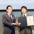 トヨタ広報部第２広報室の小川正樹メディアリレーション２グループ長（右）に表彰状とトロフィーを授与
