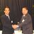 固い握手を交わす大家新支部長（右）と谷口前支部長