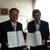 協定書を掲げる荒田理事長㊧と上岡町長