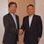 新旧理事長の握手でバトンタッチした（右が鈴木新理事長）