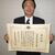 表彰状を手にする島竜彦理事長