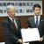 協定書を手に持つ大野徹理事長(左)と湯崎英彦知事(右)