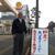 真壁さん（左）の風刺がきいた看板はいつも話題に（長崎市で）