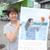 仕事も組合も笑顔で元気に。由希子さんのポスターを持つ荒金さん（荒金石油ＳＳで）
