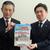 小泉前県教育長にクリアファイルを手渡す相山委員長（左）