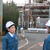 施設の説明を受ける西村大臣（左）