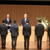 新入社員に辞令を交付する関社長（ステージ奥中央）